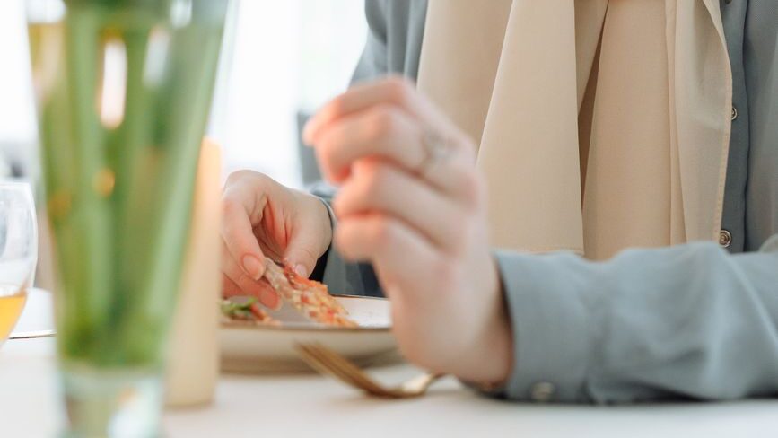smiling woman in white hijab sitting by the table